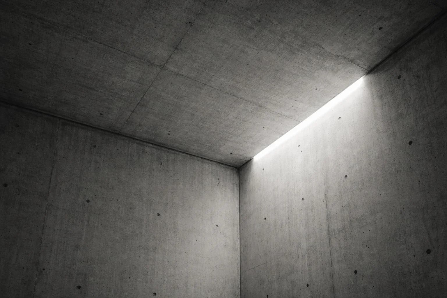 A concrete room corner lit by a single beam of light